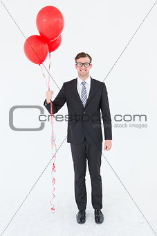Happy geeky hipster businessman holding balloons