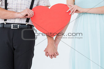 Hipster couple holding heart card