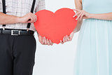 Hipster couple holding heart card