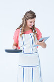 Happy hipster woman holding laptop and frying pan