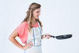 Happy hipster woman holding frying pan