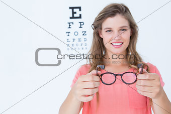 Hipster showing glasses next to an eye test