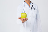 Doctor showing apple to camera