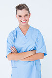 Smiling nurse in blue scrubs posing with arms crossed