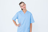 Serious nurse in blue scrubs posing with hand on hip