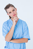 Thoughtful nurse looking at camera with hand on chin