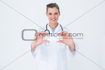 Happy doctor holding card