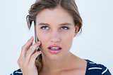 Unsmiling woman calling with her smartphone