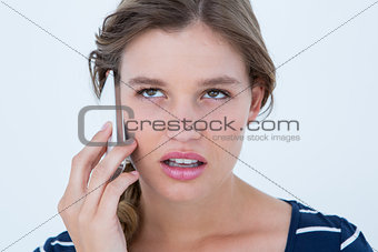 Unsmiling woman calling with her smartphone