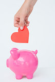 Woman holding piggy bank and red heart