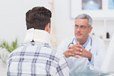 Doctor looking at patient wearing neck brace