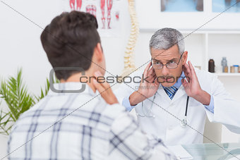 Doctor examining patient with neck ache