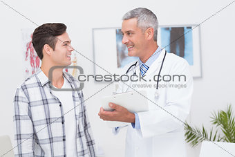 Doctor showing clipboard to his patient