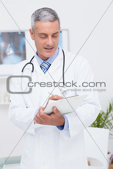 Happy doctor writing on clipboard