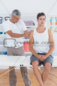 Doctor examining his patient shoulder