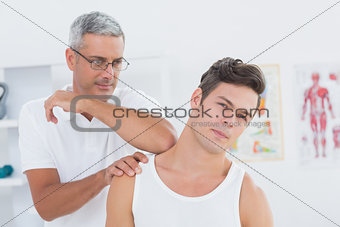 Doctor stretching a young man neck