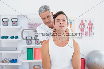 Doctor massaging a young man neck