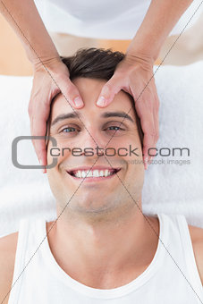 Smiling man receiving head massage