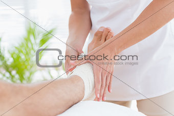 Doctor examining her patient ankle