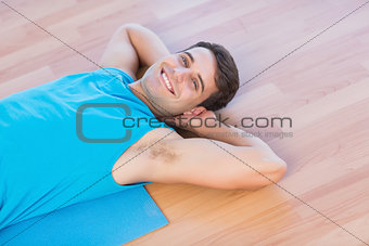 Smiling man lying on exercise mat