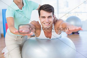 Trainer with man on exercise ball