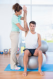 Man stretching his arm with trainer