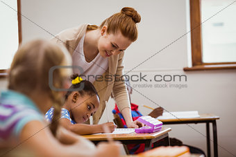 Teacher helping a little girl during class