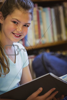 Little girl reading on library floor