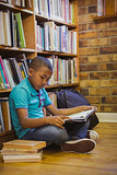 Little boy reading on library floor