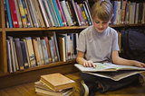 Little boy reading on library floor
