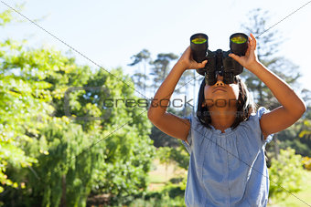 Cute little girl looking through binoculars