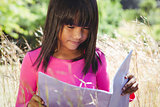 Cute little girl reading in park