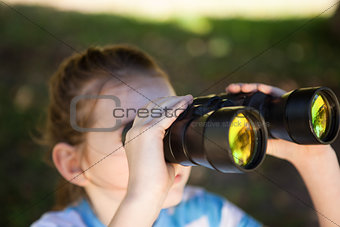 Cute little girl looking through binoculars