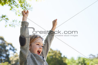 Cute little boy cheering in park