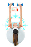 Composite image of woman exercising with dumbbells on fitness ball