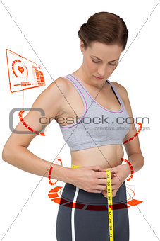 Composite image of portrait of a fit woman measuring waist