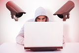 Composite image of serious burglar hacking into laptop