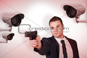 Composite image of serious businessman pointing a gun