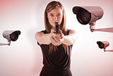 Composite image of femme fatale pointing gun at camera