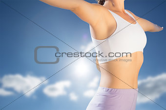 Composite image of sporty blonde standing on the beach with arms out