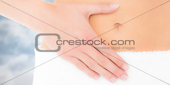 Composite image of mid section of a fit woman with hand on stomach