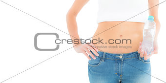 Mid section of a fit woman holding a bottle of water
