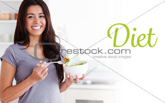 Diet against beautiful woman enjoying a bowl of salad while standing