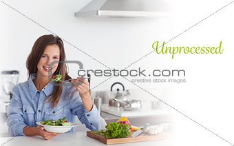 Unprocessed against woman eating a vegetarian salad