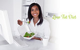 Low fat diet against happy pretty businesswoman eating a salad at her desk