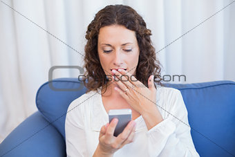 Surprised woman looking at her mobile phone