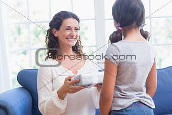 Cute girl offering gift to her mother