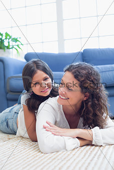 Happy mother and daughter lying on the floor