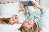 Happy mother and daughter using tablet