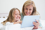 Happy mother and daughter using tablet